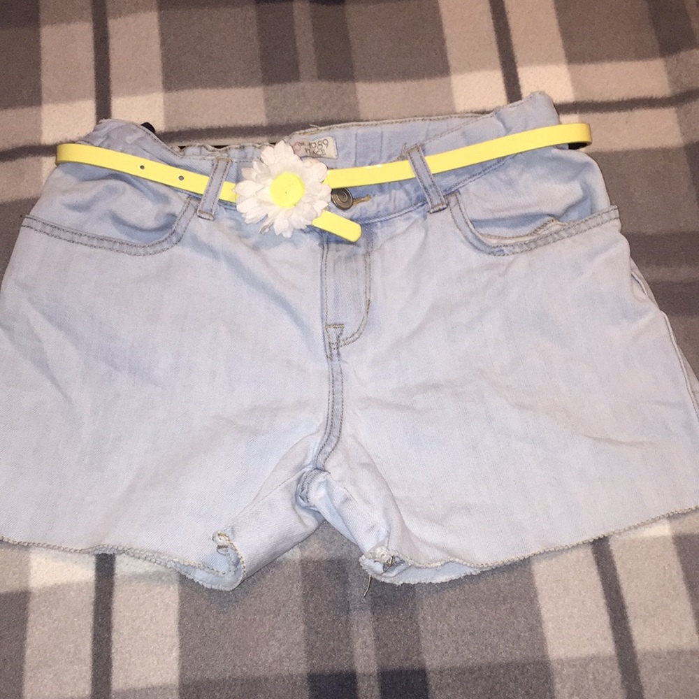 Girls denim shorts with yellow belt.